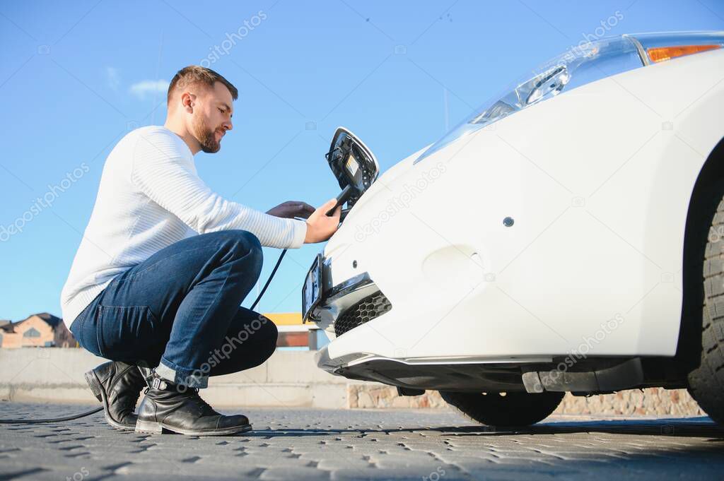 Young man charging his car
