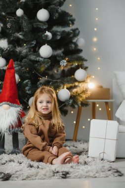 Mutlu, küçük, gülümseyen kız Noel hediyesi kutusuyla.