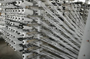 Endüstriyel kumaş üretim hattı. Bir tekstil fabrikasında dokuma tezgahı