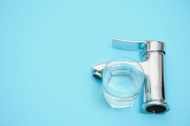 Açık mavi arkaplanda tek kulplu su musluğu, yakın plan