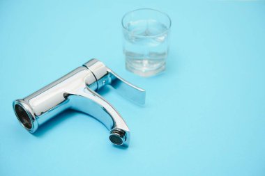 Açık mavi arkaplanda tek kulplu su musluğu, yakın plan