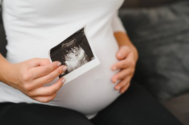 Elinde yankı resimleri tutan hamile kadınlar.
