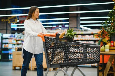 Satış, alışveriş, tüketim ve insanlar kavramı - bakkal ya da süpermarket gıda sepeti kadınla