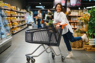 Satış, alışveriş, tüketim ve insanlar kavramı - bakkal ya da süpermarket gıda sepeti kadınla