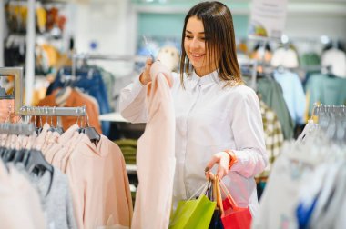 Alışveriş yapan bir kadın. Alışveriş torbalarıyla alışveriş yapan mutlu bir kadın. Tüketim, alışveriş, yaşam tarzı konsepti