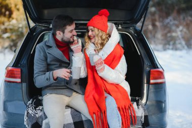 Tatlı bir çift, Kış Ormanı pikniğinde çay içiyorlar. Doğa pikniği. Arabadaki Aşk Hikayesi.