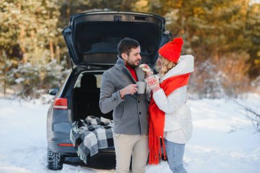 Birlikte gülümsüyoruz. Güzel bir çift kışın kırda bir hafta sonu geçirir. Modern arabanın arka tarafında oturuyor..