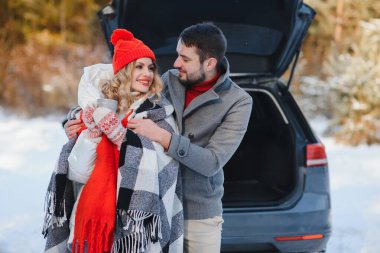 genç bir çift kırmızı kareli bir sıcak çay tutan korunaklı