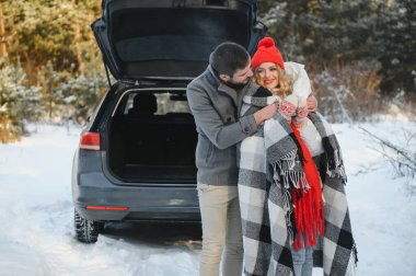 genç bir çift kırmızı kareli bir sıcak çay tutan korunaklı