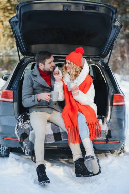 Tatlı bir çift, Kış Ormanı pikniğinde çay içiyorlar. Doğa pikniği. Arabadaki Aşk Hikayesi.