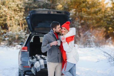 Tatlı bir çift, Kış Ormanı pikniğinde çay içiyorlar. Doğa pikniği. Arabadaki Aşk Hikayesi.