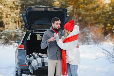 Tatlı bir çift, Kış Ormanı pikniğinde çay içiyorlar. Doğa pikniği. Arabadaki Aşk Hikayesi.