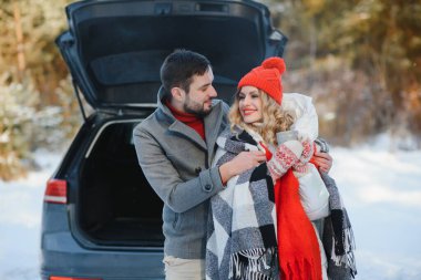 Tatlı bir çift, Kış Ormanı pikniğinde çay içiyorlar. Doğa pikniği. Arabadaki Aşk Hikayesi.