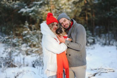 Sevgi dolu bir çift, karlı bir ormanın arka planında yürür. Bir adam bir köpek tutuyor. Beyaz ceketli ve kırmızı şapkalı bir kız..