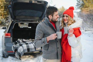 genç bir çift kırmızı kareli bir sıcak çay tutan korunaklı