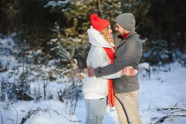 Winter picnic in the forest. Love story in snow. couple in winter play in snow and hugging near the pine. Two lovers on winter walk. Valentine\'s Day for couple in rustic style. Winter lovestory