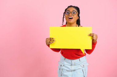 Sanırım öyle. Düşünceli afro kadın boş konuşma balonuna bakıyor, çenesine dokunuyor, telif alanı, pembe stüdyo duvarı.