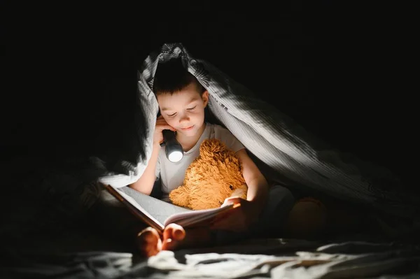 Menino Com Lanterna Livro Leitura Sob Cobertor Casa — Fotografia de Stock