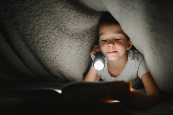 Menino Com Lanterna Livro Leitura Sob Cobertor Casa — Fotografia de Stock