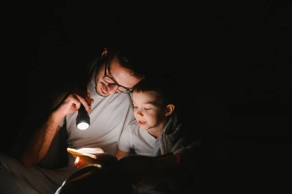 Vater Und Sohn Mit Taschenlampe Lesebuch Unter Decke Hause — Stockfoto