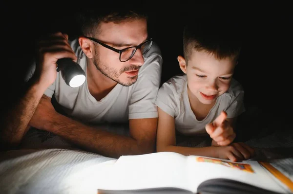 Vater Und Sohn Mit Taschenlampe Lesebuch Unter Decke Hause — Stockfoto