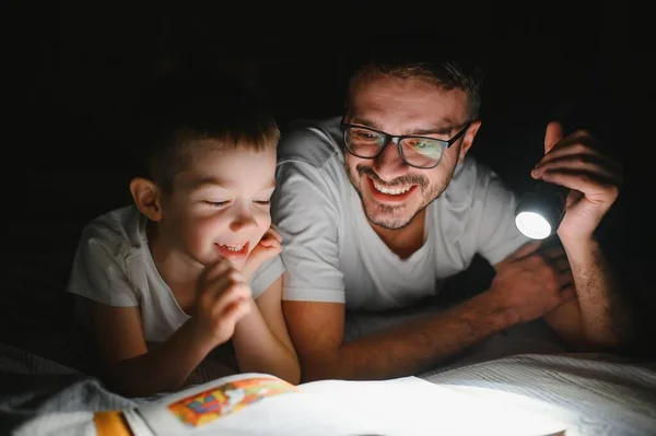 Vater Und Sohn Mit Taschenlampe Lesebuch Unter Decke Hause — Stockfoto