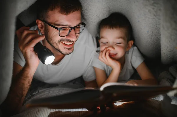 Vater Und Sohn Mit Taschenlampe Lesebuch Unter Decke Hause — Stockfoto