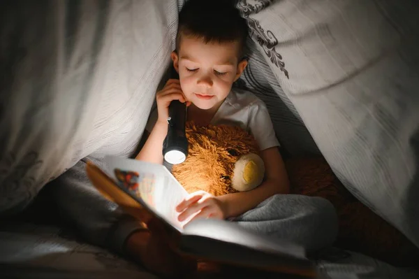 Pojke Åldern Läser Bok Kvällen Mörkret Filt Med Leksaksbjörn — Stockfoto