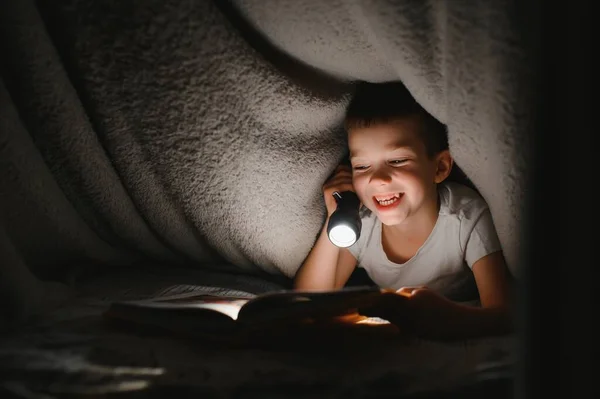 Pojke Med Ficklampa Läsa Bok Filt Hemma — Stockfoto