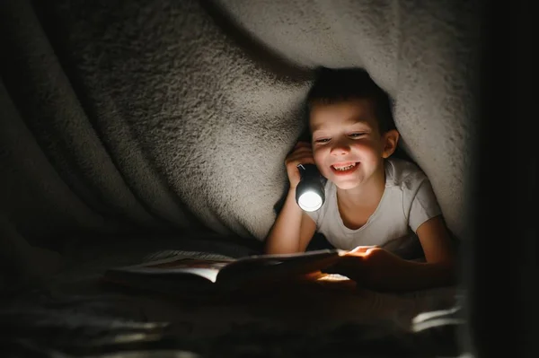 Pojke Med Ficklampa Läsa Bok Filt Hemma — Stockfoto