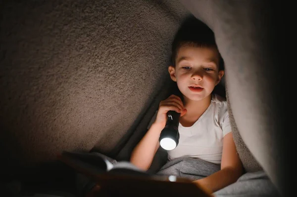 Niño Con Linterna Libro Lectura Bajo Manta Casa —  Fotos de Stock