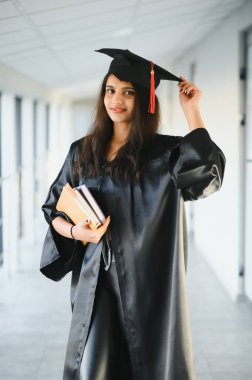 Genç Asyalı bayan mezun bornozla mezun oldu. Hayatta başarı. Kendine güvenerek öğrenme.