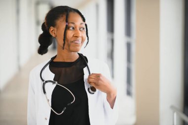 Hastanede gülümseyen Afrikalı Amerikalı kadın doktor portresi.