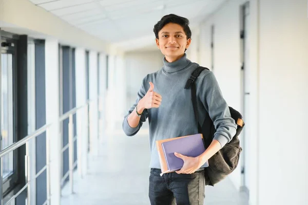 Elinde kitap tutan Hintli üniversiteli çocuğun portresi..