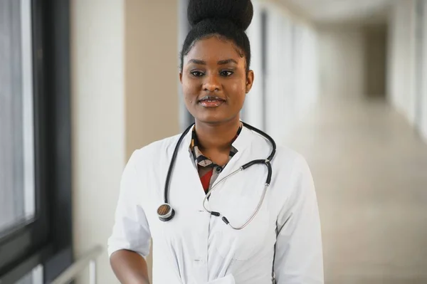 病院の廊下でアフリカ系アメリカ人女性医師が — ストック写真