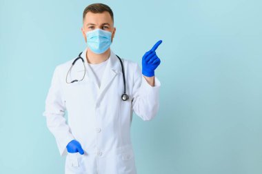 Beyaz önlüklü ve eldivenli erkek doktor elleriyle kenarı işaret ediyor. Metin alanının yanında. boş bir arkaplan