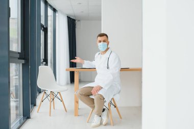 Klinikte resepsiyon masası yakınında erkek doktor