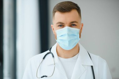 Doktor koruyucu bir maske takıyor.