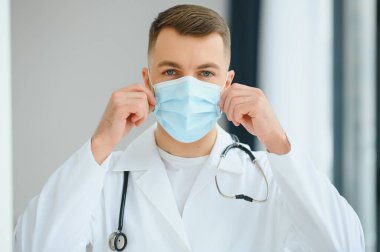 Doktor koruyucu bir maske takıyor.