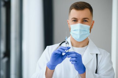 Tıp doktoru bir hasta için aşı tutuyor..