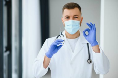 Cerrahi maske takan erkek doktorun portresi Coronavirüs veya covid virüsü olan hastalara yardım etmeye hazır..