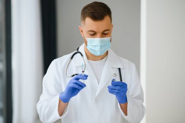 Tıp doktoru bir hasta için aşı tutuyor..