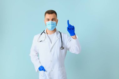 Beyaz önlüklü ve eldivenli erkek doktor elleriyle kenarı işaret ediyor. Metin alanının yanında. boş bir arkaplan