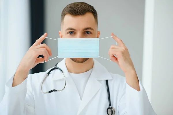 Knappe Mannelijke Dokter Medisch Uniform Zet Een Beschermend Masker Tegen — Stockfoto