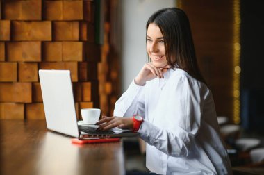 Genç kadın başarılı yönetici cep telefonu aracılığıyla olası mali şirket çalışanı ile konuşmak ve alan ortak çalışma uzak görüşme sırasında taşınabilir dizüstü bilgisayar üzerinde onların devam okuma