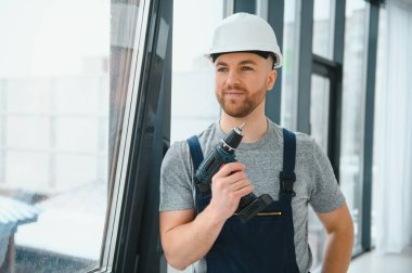 Süre installing pencere kapalı matkap kullanarak inşaat işçisi