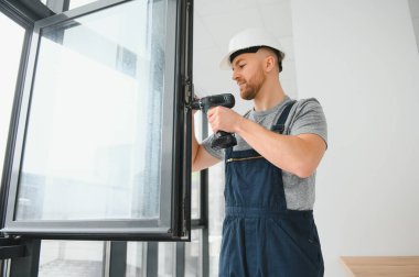 Süre installing pencere kapalı matkap kullanarak inşaat işçisi