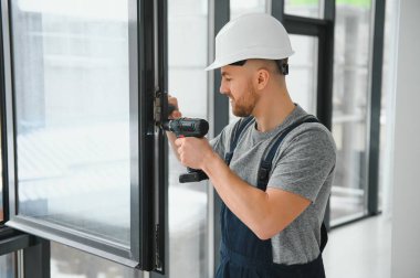 Süre installing pencere kapalı matkap kullanarak inşaat işçisi