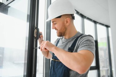 İnşaat işçisi eve pencere kuruyor