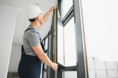 servis elemanı tornavidayla pencere kuruyor